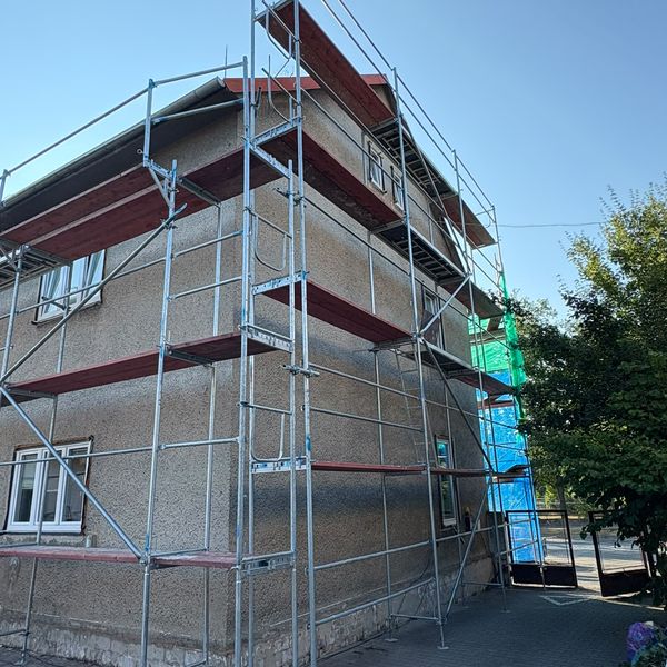 Fasádní lešení na nároží rodinného domu se zateplenou fasádou