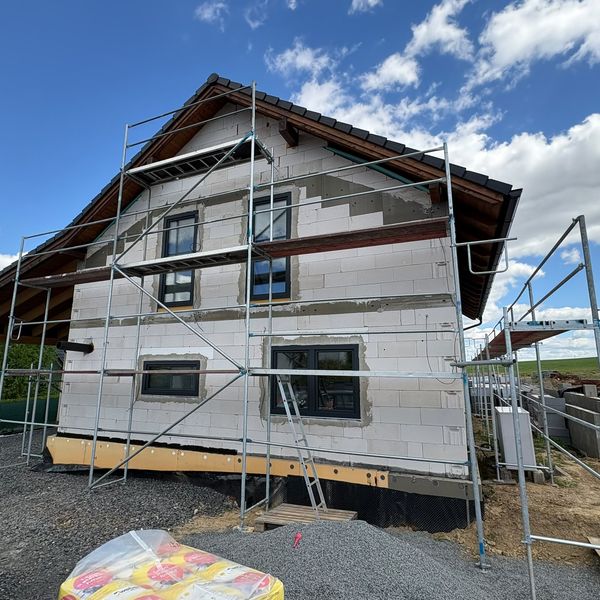 Lešení na novostavbě s rozpracovaným zateplením fasády